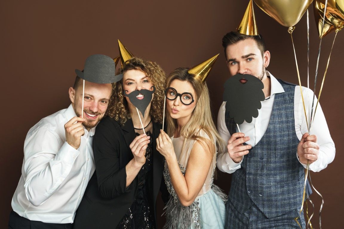 Guests using an open-air photo booth with props at a Danbury wedding
